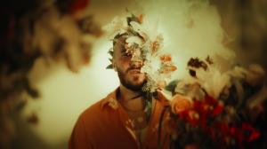 A high-resolution video still from “Speechless” featuring artist Jakub Chmelar in an expressive pose, symbolizing liberation and queer resilience