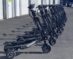 Lineup of black electric patrol scooters branded with 'Security' parked outside a facility