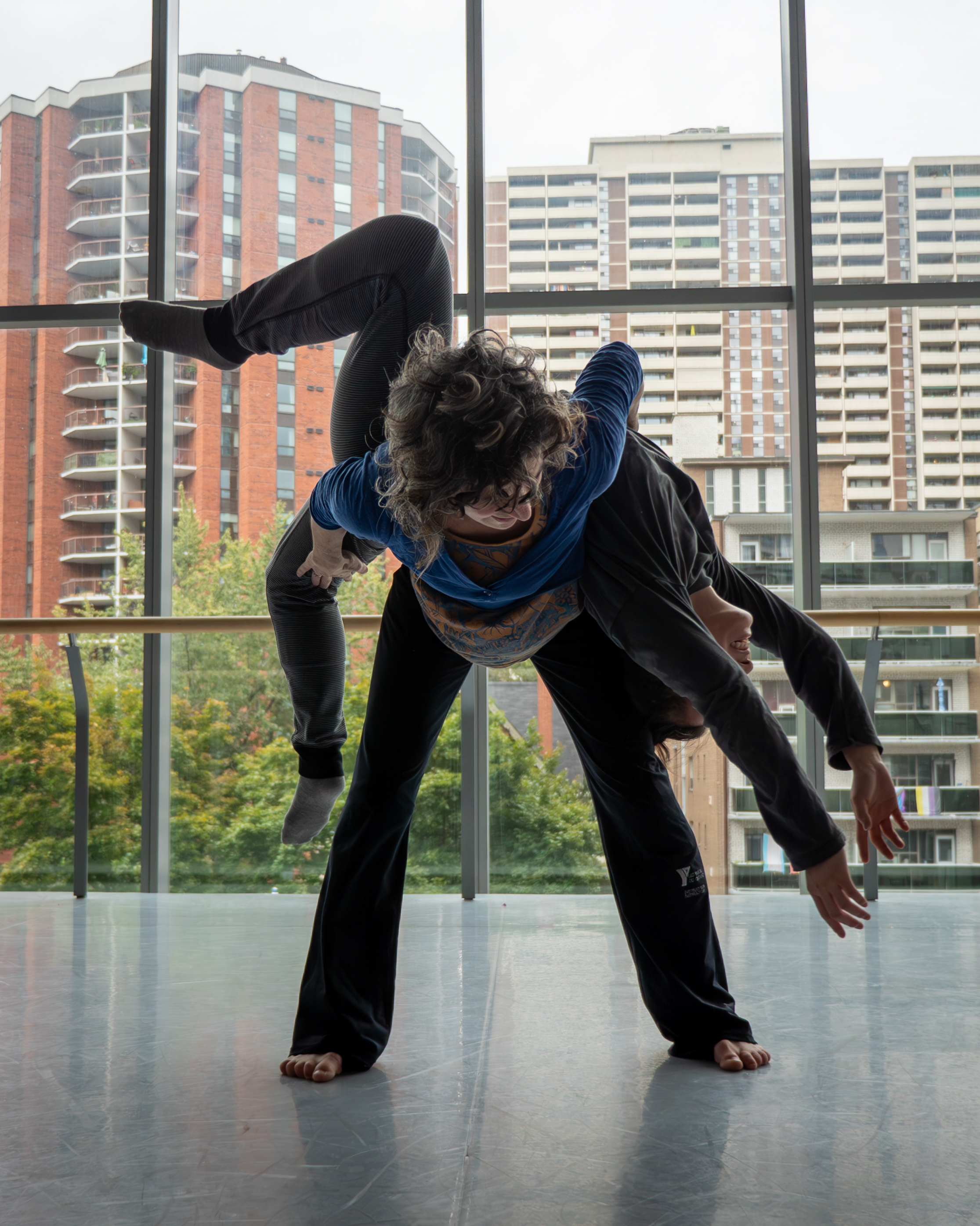 A dancer carrying another dancer on their back