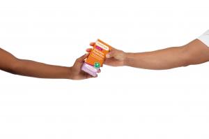 A photograph of a woman and man passing a box of FemiClear's Infection Protection for BV & Yeast to each other