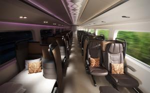 Interior view of a train cabin featuring Butterfly’s convertible seating in recliner and bed modes, with ambient lighting and Indigenous-inspired pillows.