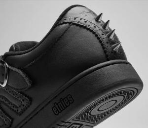 Rear angle showing the shoe’s heel crowned with sharp metal spikes and perforated leather trim above the embossed outsole logo. etnies Hardwire Kingpin