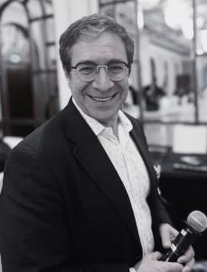 Black and white portrait of Irwin Katsof, author of Living Dangerously, wearing a joyful expression. Katsof is known for his work in spiritual leadership, business diplomacy, and emotional healing.