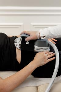 Close-up of Emsculpt Venus Ab Rehab treatment in progress at CoreLife Wellness in Oakville, showing hands positioning the HIFEM device on a patient’s abdomen to target diastasis recti and core weakness.