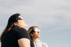 Mujeres viendo con seguridad el eclipse solar