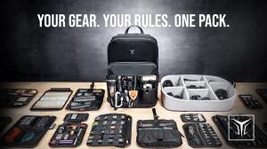 Hero image of the VAULT3 modular backpack displayed front and center on a table, surrounded by removable organization panels, EDC tools, and a modular camera cube, with the slogan “Your Gear. Your Rules. One Pack.” featured above.