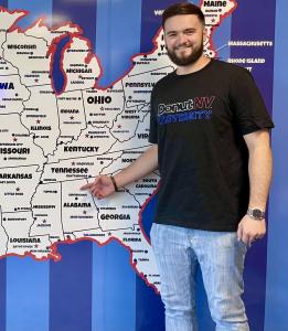 Photo of new franchise owner pointing to a map picturing his operating location