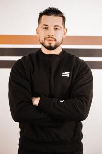Brian Velez founder of Physical Culture Brooklyn standing in training facility representing leadership in personalized fitness coaching.