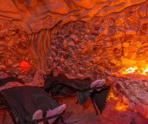 People relaxing in a Himalayan salt cave surrounded by glowing salt walls and soft lighting
