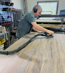 Sanding a new piece of custom furniture.