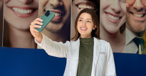 Woman taking photo of her teeth inside a diamond braces dental office