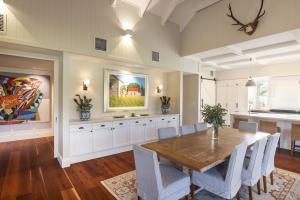 Dining room in Gregor’s Creek home with timber floors, vaulted ceiling, custom cabinetry, and framed artwork, designed by Dion Seminara Architecture.