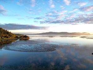 View of Tillamook Bay at sunset with clouds and a glowing sky