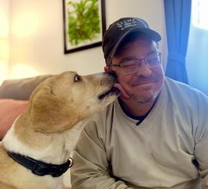 Labrador / beagle mix, Duncan, gives his owner Paul a lick on the cheek