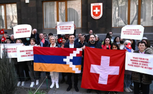 Armenians hold up the flags of Nagorno Karabakh and Switzerland during a rally in Yerevan