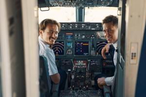 Two commercial airline pilots inside the cockpit before takeoff, symbolizing the need for specialized addiction treatment programs like Asana Recovery’s rehab for pilots.