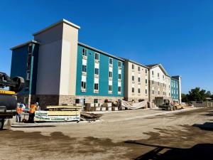 Front exterior view of the WoodSpring Suites Santee hotel, newly completed by Level 3 Construction as part of a ground-up hotel construction project for repeat client Gold Coast Premier Properties. This project showcases the company's hospitality construc