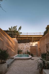 View of the pool at the back of Portal 62, with a rammed-earth wall on the right hiding the stairway to the underground cave.