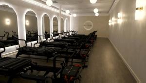 Darkened room with Reformer Lagree Pilates machines
