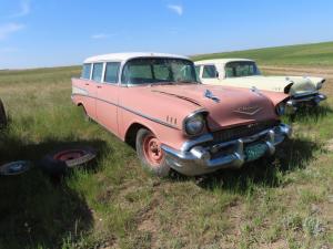 1957 pink and white Chevrolet Belair 4dr wagon. Very clean, some glass cracked. Black and silver bench seat. 283 V8 with automatic transmission. Not running. Odometer shows 52,187.