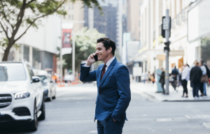 Australian man starting a business using Honcho on his phone on the streets of Sydney Australia.