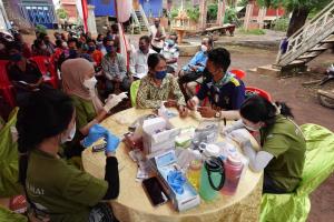 Project DAMAI members checking villagers' vitals during a mobile clinic
