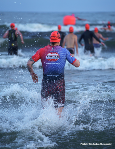 Tri CLE Ambassador enters Lake Erie at the start of the swim portion of the 2024 race, wearing a wetsuit and swim cap.