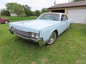 Baby blue 1967 4-door Lincoln Continental convertible with suicide doors and white top, powered by a 462 V8 engine with automatic transmission. The odometer shows 75,257 miles.