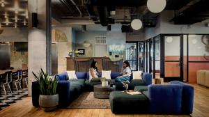 Senior employee mentoring younger team member about 401(k) options in a collaborative office setting