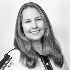 black and white headshot of a woman who is smiling at the camera for her professional headshot