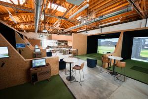 Four Wood Golf Club interior photo showing six hi-tech simulator bays and clubhouse lounge bar