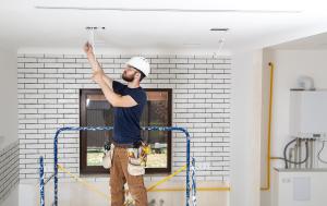 Astron Electric employee installing wiring inside a residential home