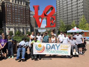 People with and without disabilities holding Day for Tomorrow banner at Love Park in Philadelphia